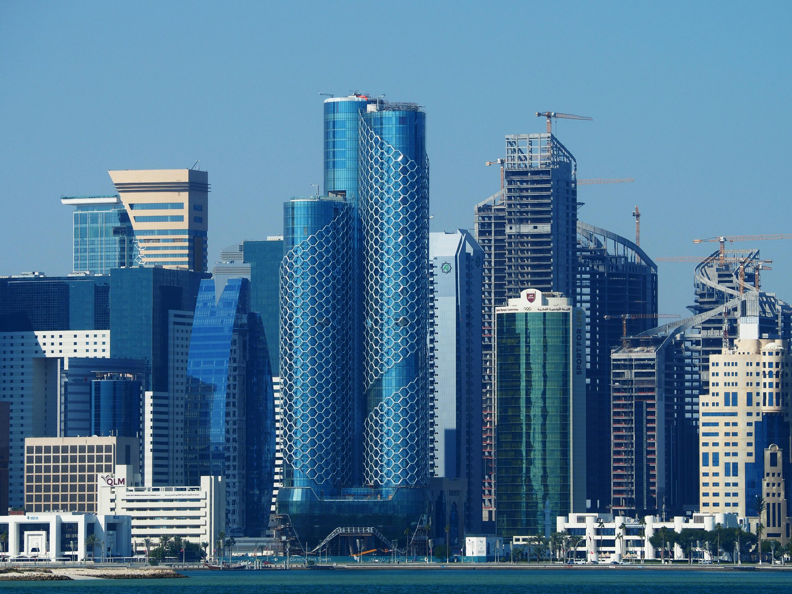 Home Explore the futuristic skyline of Doha, showcasing modern architectural designs and towering skyscrapers.